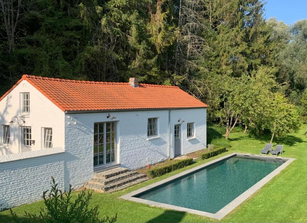 une petite maison avec une piscine dans la cour dans l'établissement Petite maison privative dans un environnement idyllique, à Lasne