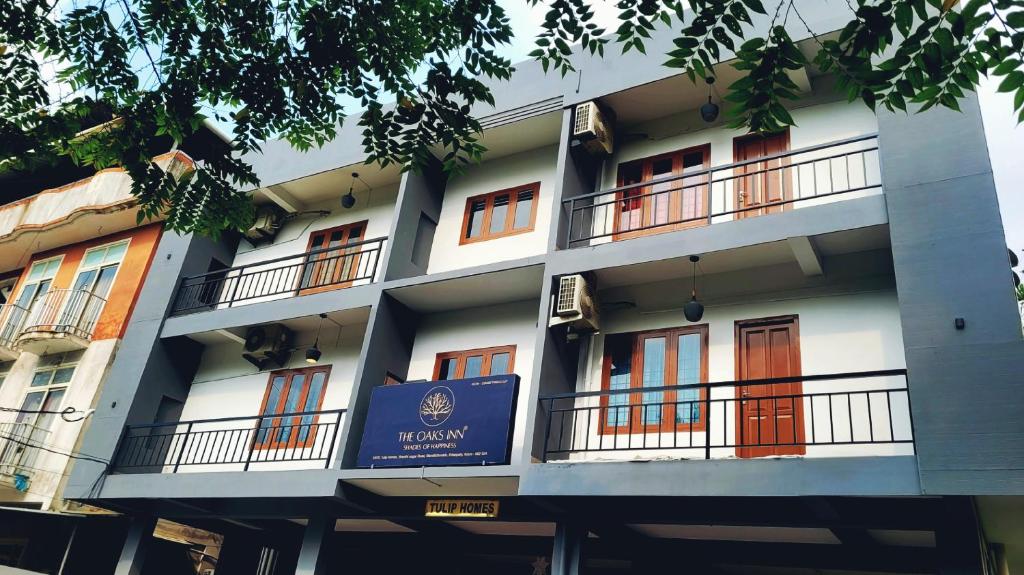 a building with a blue sign in front of it at Tulip Homes by The Oaks Inn in Cochin