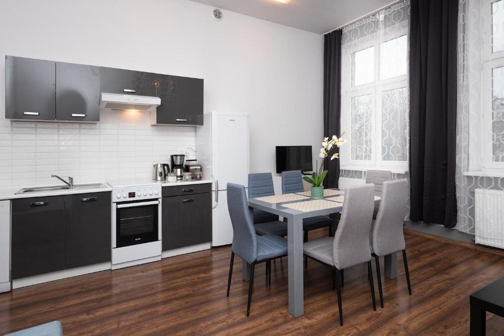 a kitchen with a table and chairs and a kitchen with black cabinets at Dietla 57, two-bedroom apartment with living room, apartment 24 , Ulysses in Krakow