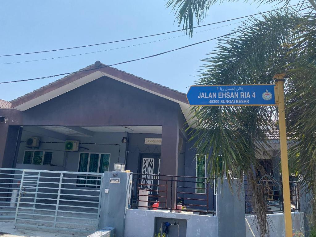 une maison avec un panneau bleu de rue devant elle dans l'établissement Humayyah Homestay, à Sungai Besar