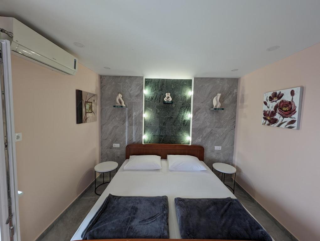 um pequeno quarto com uma cama e 2 bancos em Apartments Klenovica Jadranka Čačić em Klenovica