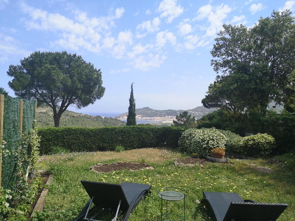 un giardino con due sedie e un tavolo di Cap de Creus : bungalow, jardin y vista al mar. a La Selva de Mar
