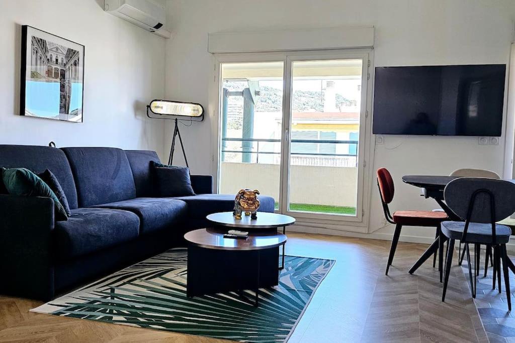 un salon avec un canapé bleu et une table dans l'établissement L'exquis 800m plage et croisette, à Cannes