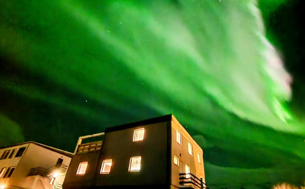 un bâtiment avec l'aurore dans le ciel dans l'établissement Aurora Guesthouse, à Grundarfjörður