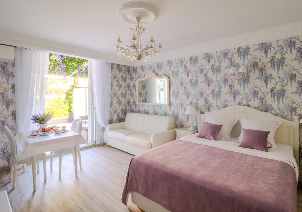 カンヌにあるCannes Imperial Croisette Palais Miramarのベッドとソファとテーブルのある寝室