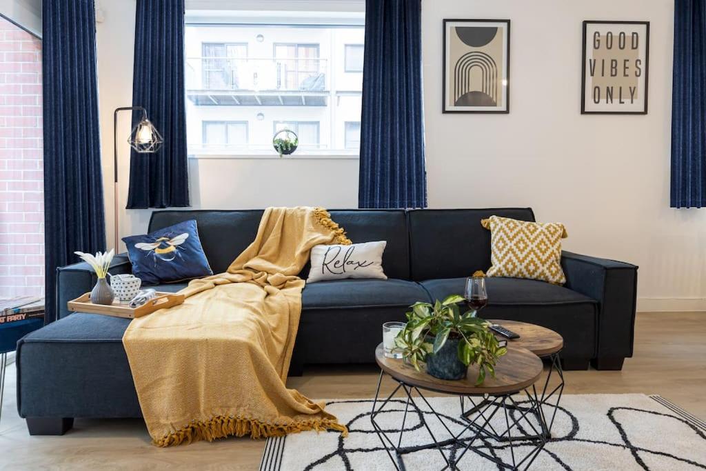 a living room with a blue couch and a table at City Centre - Luxe 2Bed Palazzo in Manchester