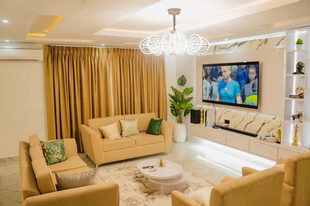 uma sala de estar com dois sofás e uma televisão em 3 bedroom service apartment Victoria Island Aij Residence em Lagos