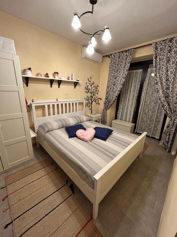 una camera da letto con un letto con un cuscino rosa di A Casa del Ferdy a Caserta