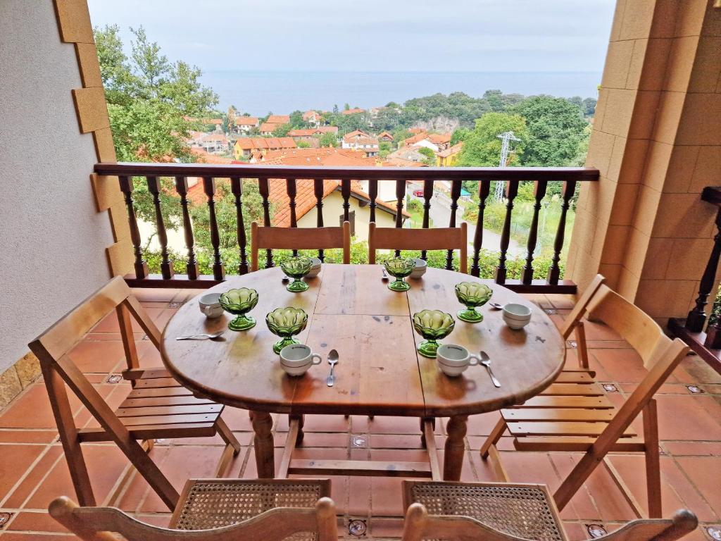 a wooden table on a balcony with chairs at Villa Rural Cantabria in Pechón