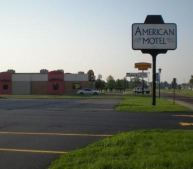 un cartel de motel americano al lado de una calle en American Motel Waseca, en Waseca