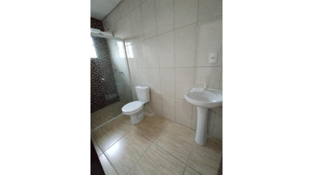 a bathroom with a toilet and a sink at Casaville in Joinville