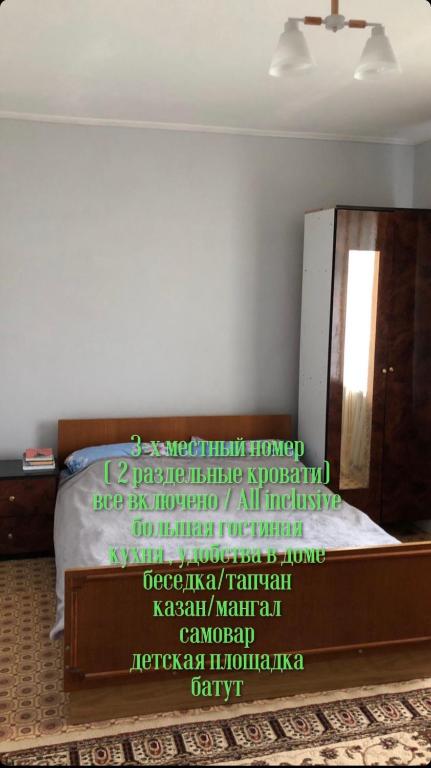 a bedroom with a bed with a sign on it at Bura Eco House in Borovoye