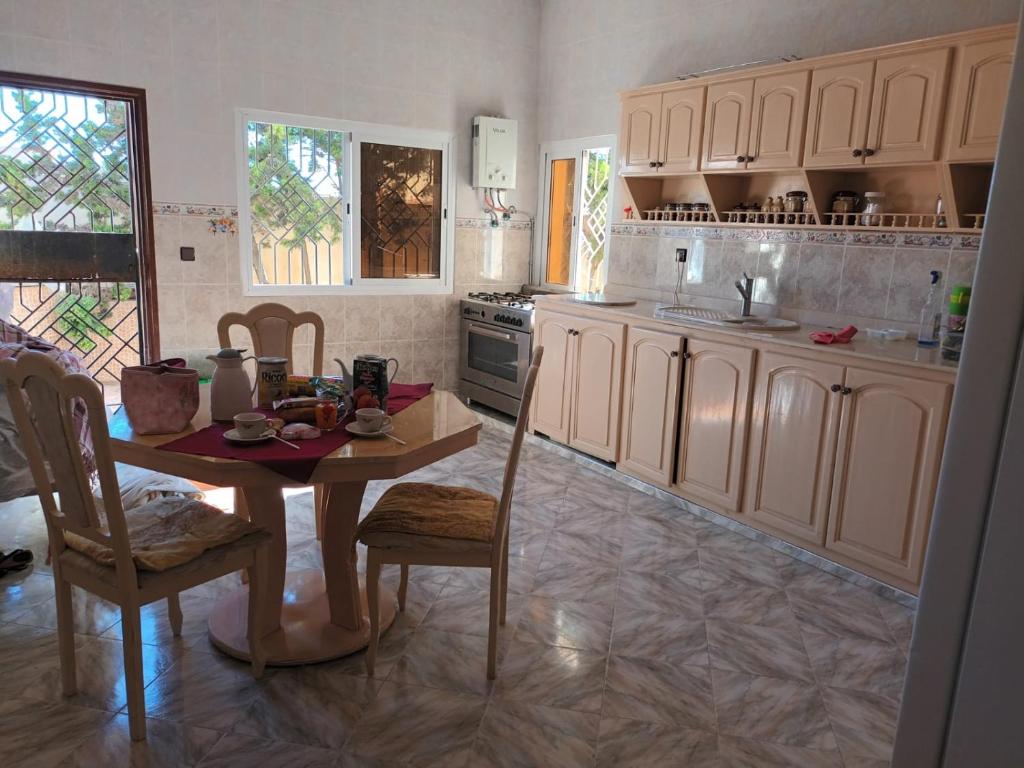 a kitchen with a table and chairs in a room at Villa Sarah in Ifoutatsene