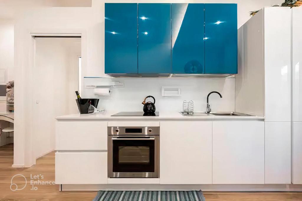 a kitchen with white counters and blue cabinets at Interno 4 - Luxury Holiday Rome in Rome