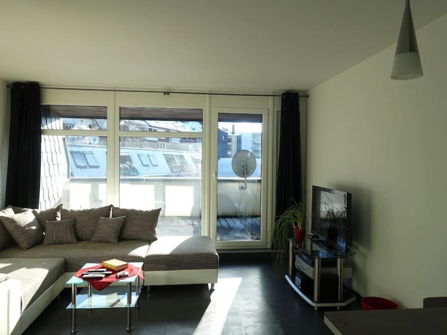 uma sala de estar com um sofá e uma grande janela em Central & Quiet: 2 Minutes to the Train Station em Lehrte