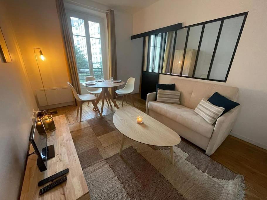 un salon avec un canapé et une table dans l'établissement Cosy au centre de Paris, à Paris