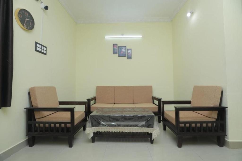 um quarto com duas cadeiras e uma mesa com caixas em The Delux Cabin em Kāraikkudi