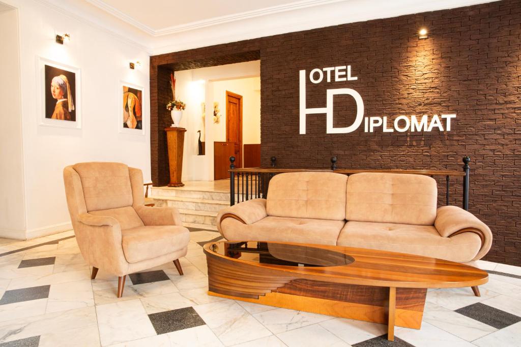 a living room with a couch and two chairs at Hotel Diplomat in Tbilisi City