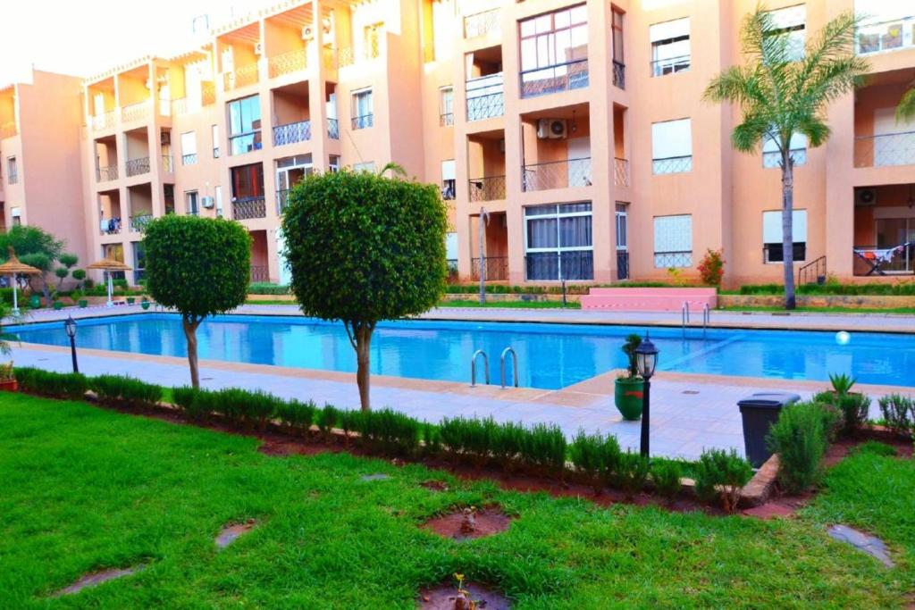 - une piscine en face d'un immeuble dans l'établissement RICO FLORES PALM BENSLIMANE, à Mohammedia