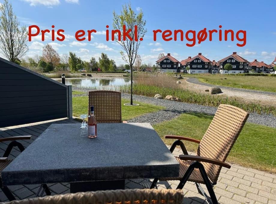 a picnic table with a bottle of beer on it at Fantastisk lejebolig med direkte udsigt til sø in Bogense