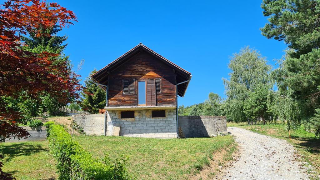 una pequeña casa en una colina al lado de un camino de tierra en OAZA VISOKO, en Visoko
