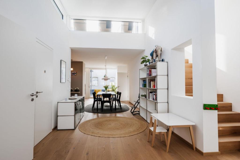 uma sala de estar e de jantar com paredes brancas e pisos de madeira em Luxus Penthouse mit Panoramablick em Bad Ischl