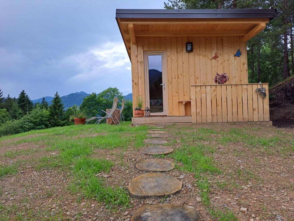 eine kleine Hütte mit einer Tür auf einem Feld in der Unterkunft Glamping hiška Gril in Ljubno
