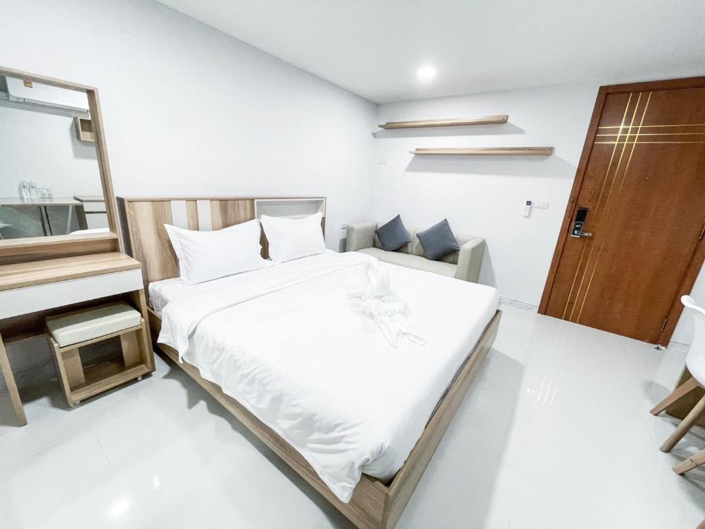 um quarto branco com uma cama e um espelho em S&Y Apartment em Ban Nong Waeng