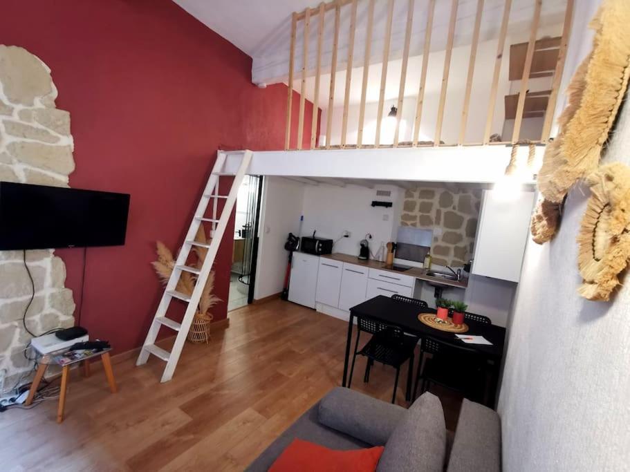 Il comprend un salon avec une mezzanine et une cuisine. dans l'établissement Centre ville Montpellier - Appartement au coeur de l'écusson, à Montpellier