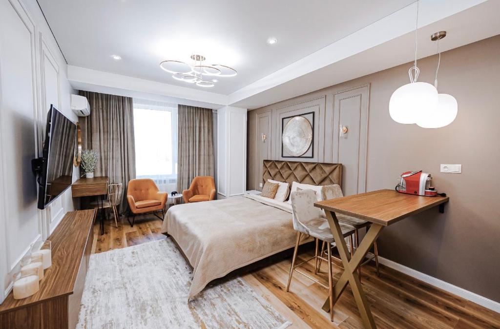 um quarto com uma cama, uma mesa e uma secretária em New Oasis Premier-Inn flats em Chisinau