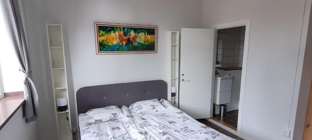 - un petit lit dans une chambre avec une photo sur le mur dans l'établissement Skeppsgården B&B, à Valdemarsvik