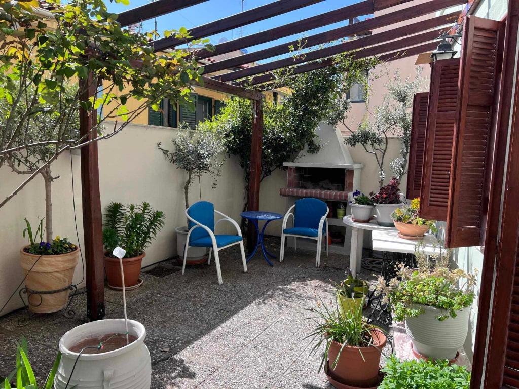 Retro House with Garden in Anopoli في سلانيك: فناء مع كراسي وطاولة مع نباتات