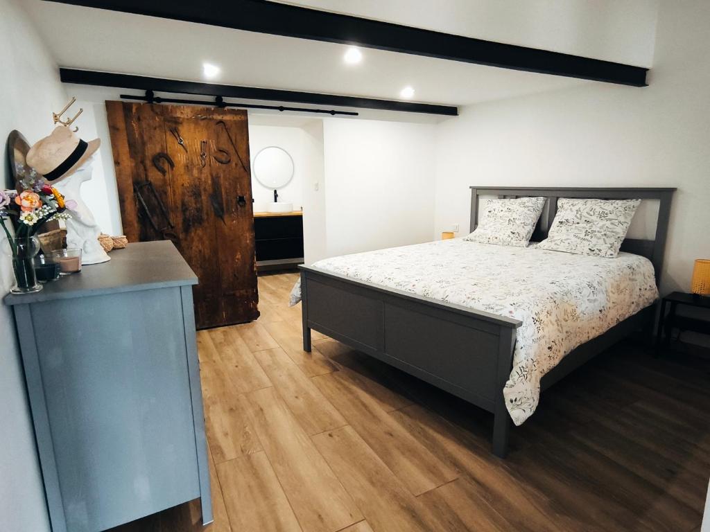 1 dormitorio con 1 cama y suelo de madera en Gîte de l'atelier, en Saint-Privat