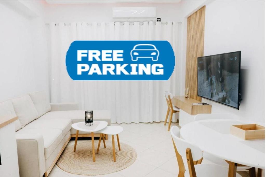 a living room with a free parking sign on the wall at White&Wood in Patra