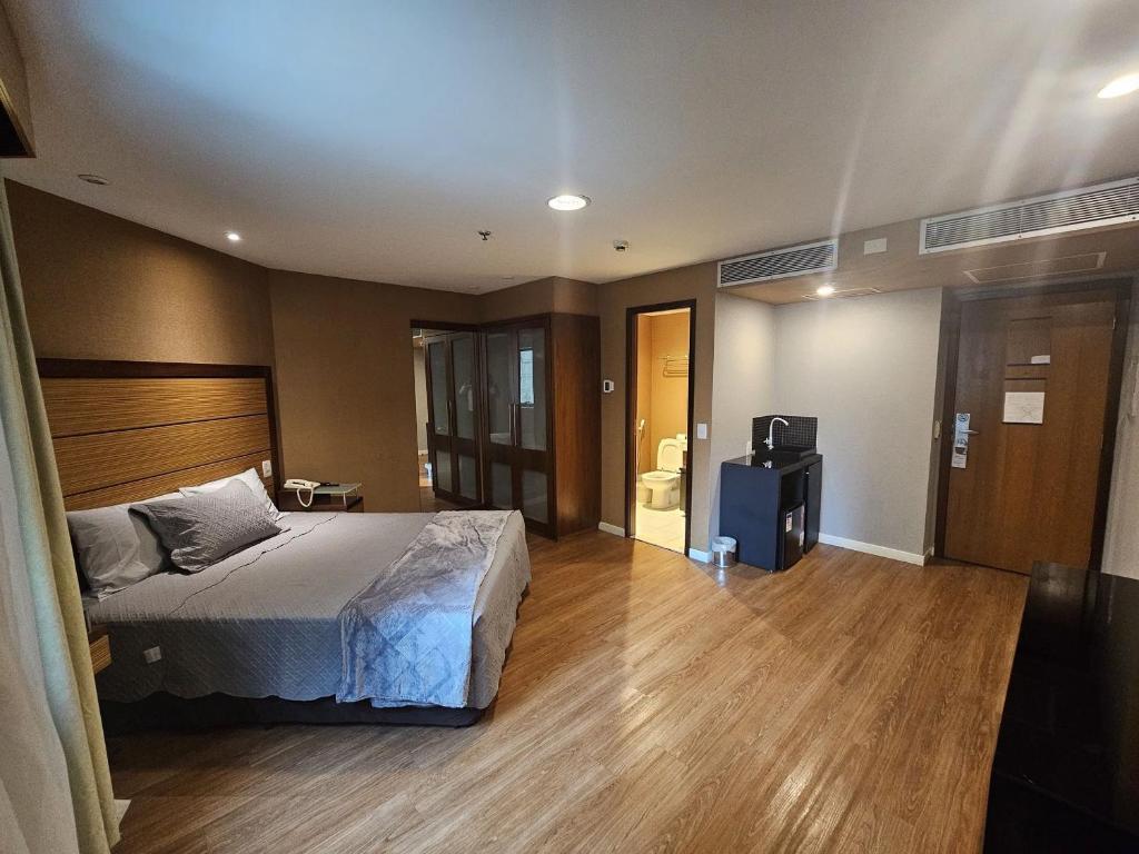 ein Schlafzimmer mit einem Bett und einem TV in der Unterkunft Flat 422 queen em hotel na avenida Ibirapuera - Moema in São Paulo