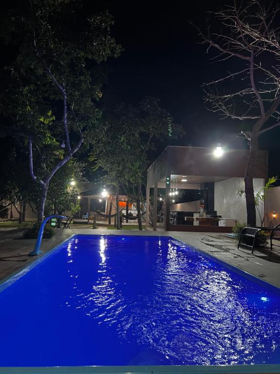 - une piscine avec des lumières bleues la nuit dans l'établissement Villaggio das Árvores, à Retiro