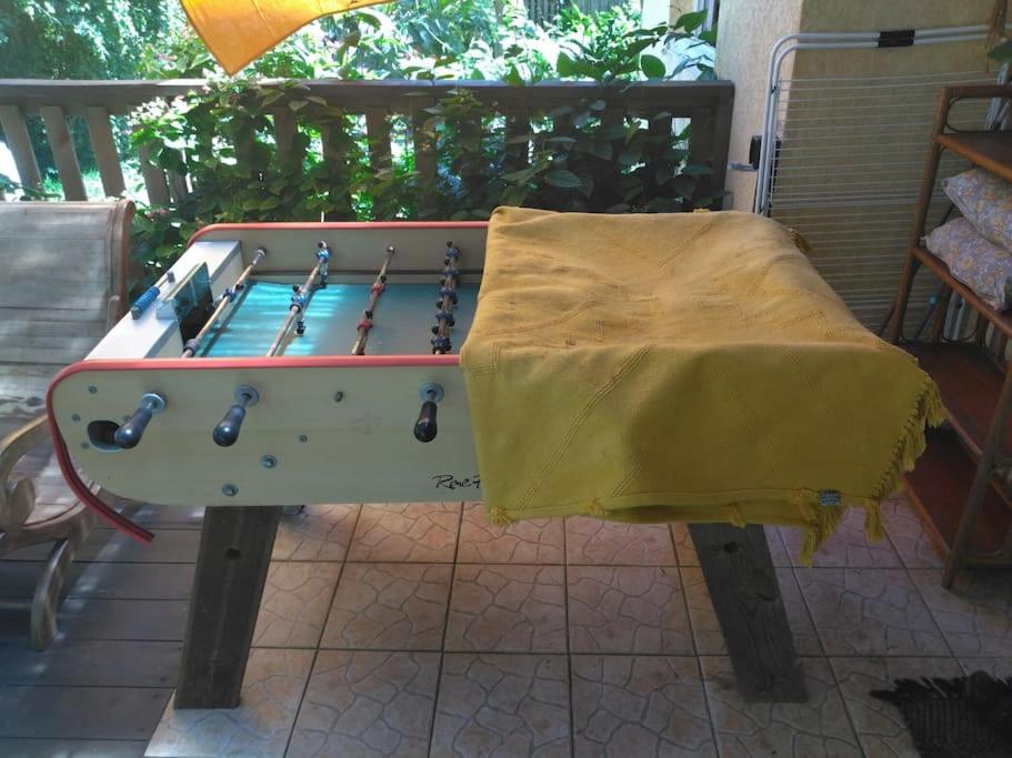 a ping pong table with a yellow cloth on it at La petite case jaune , jaccuzi pierre à 3 min à pied du bassin Manapany, vue mer in Saint-Joseph