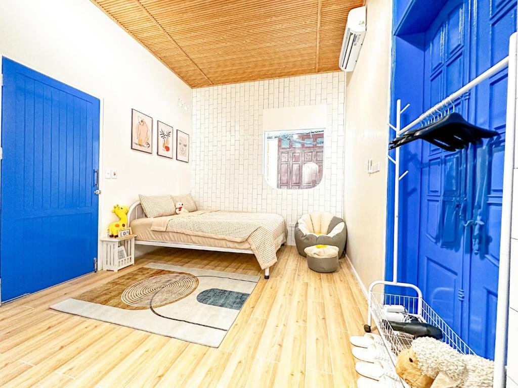 a living room with a couch and a blue door at La Casa Di Decembre - Nguyễn Như Đổ in Hanoi