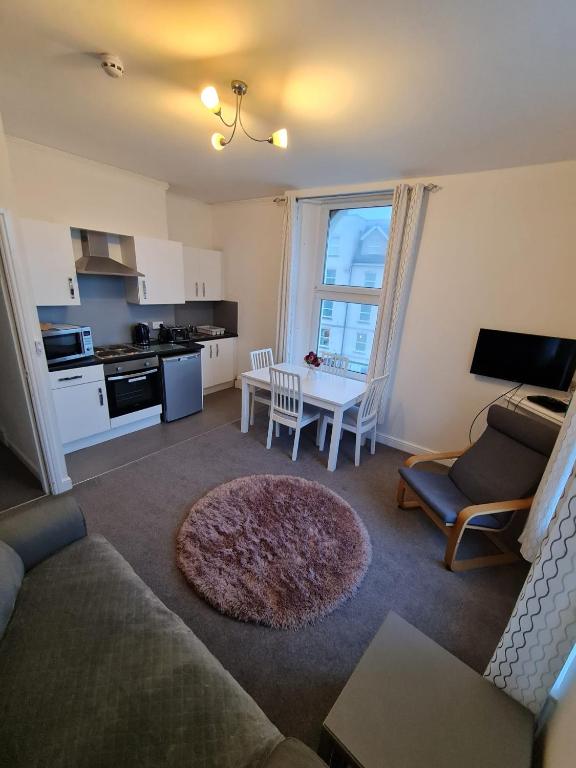 a living room with a couch and a table and a kitchen at Farina No6, Sea view apartment sleeping 4 guests in Bridlington