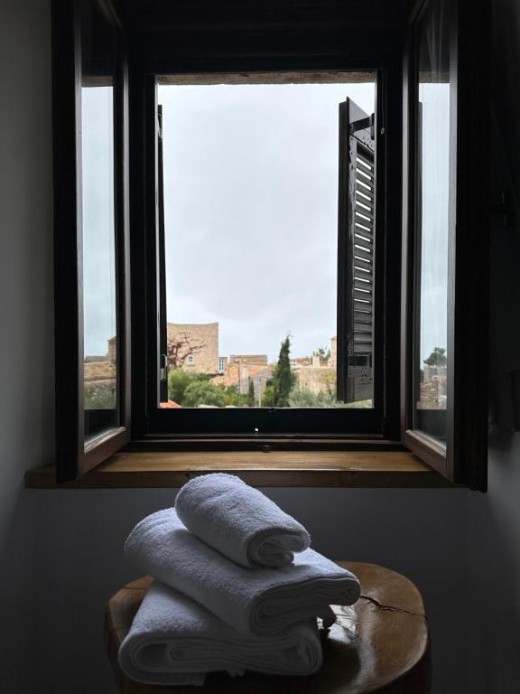 sterta ręczników siedząca przed oknem w obiekcie Èlia Luxury Rooms w mieście Areopolis