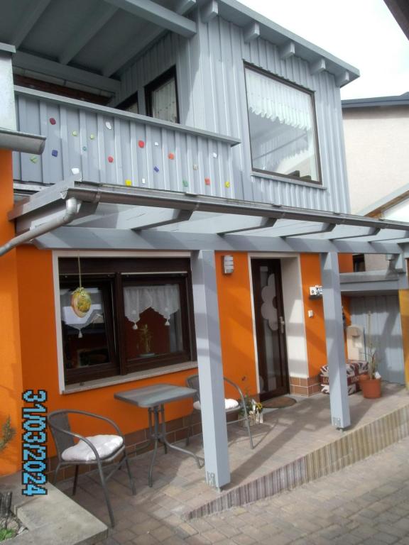 een huis met een patio met een tafel en een balkon bij Ferienhaus am Ringweg in Bad Schandau