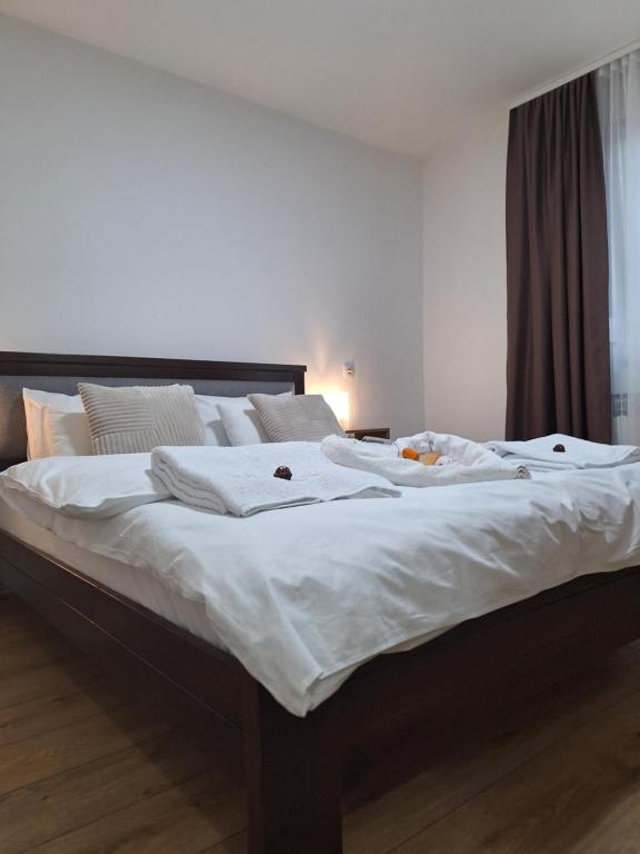 een groot bed met witte lakens en kussens bij Relax Lux apartment Nis in Niš