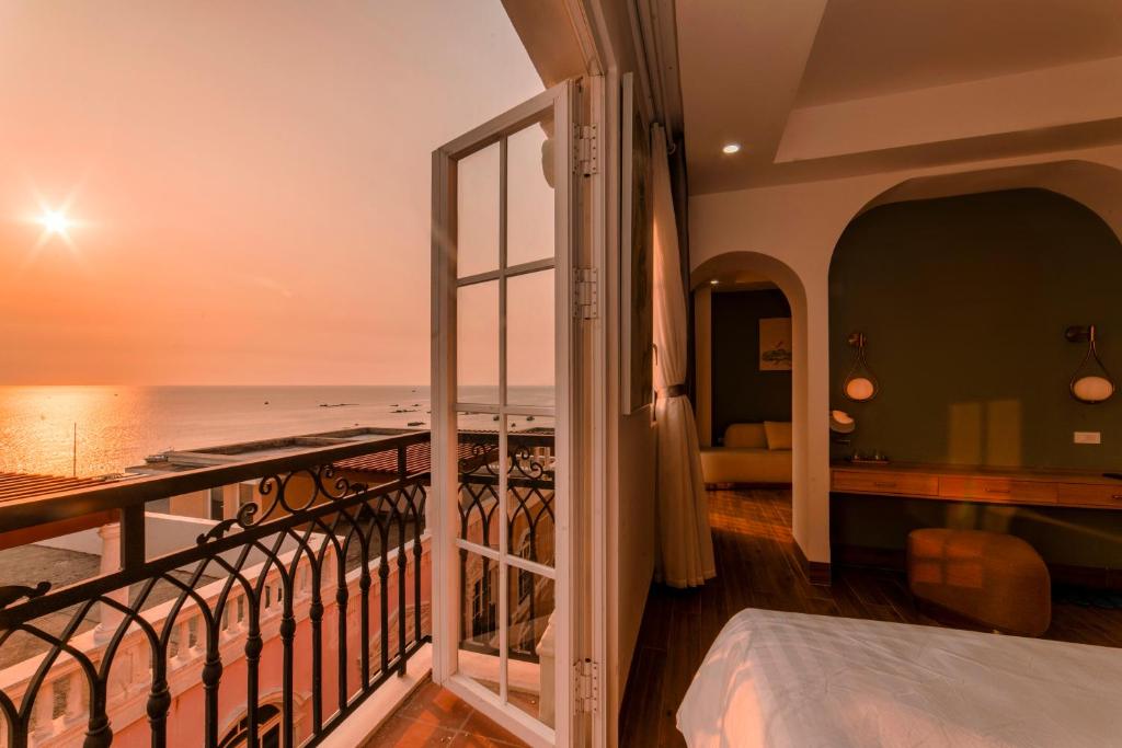 een kamer met een balkon met uitzicht op de oceaan bij Lotus Home Hillside in Phu Quoc
