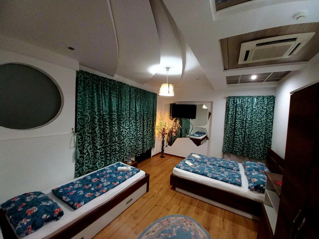 a room with two beds and green curtains at Hotel Irish in Bihać