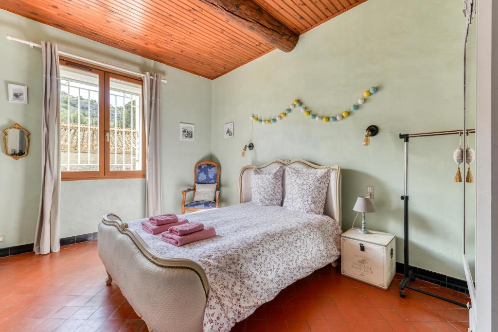 a bedroom with a bed and a window at Le Grappillon in Fitou