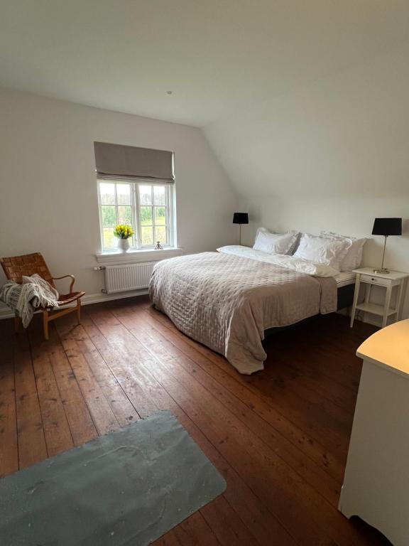 a white bedroom with a bed and a window at Sundsgården B&B in Ringe