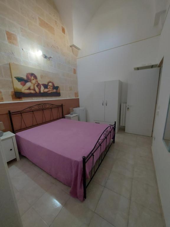 ein Schlafzimmer mit einem lila Bett in einem Zimmer in der Unterkunft Casina Arianna in Leverano