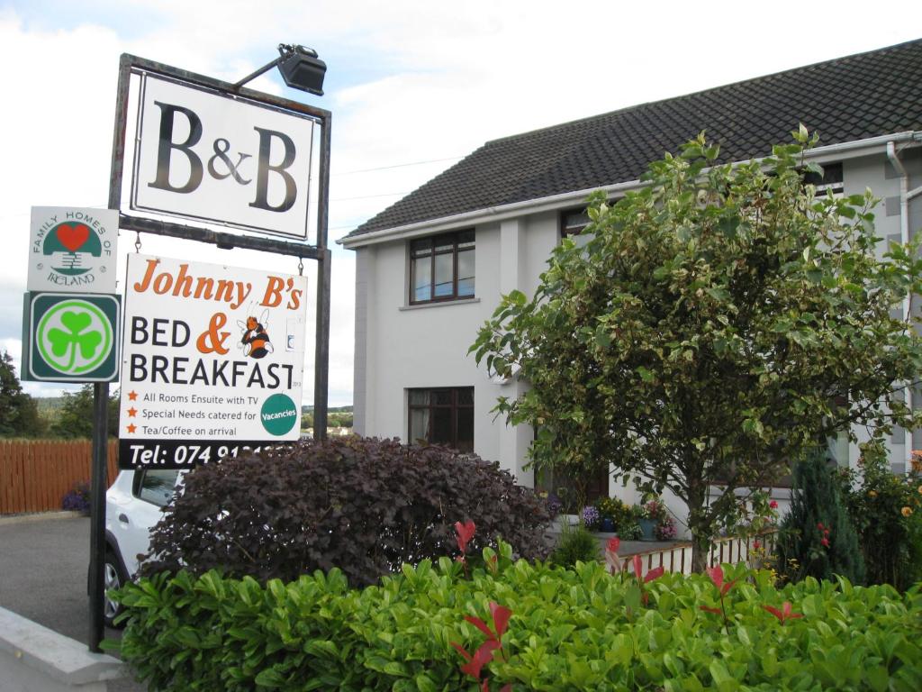 un cartel para un bed and breakfast frente a una casa en Johnny B's B&B en Ballybofey