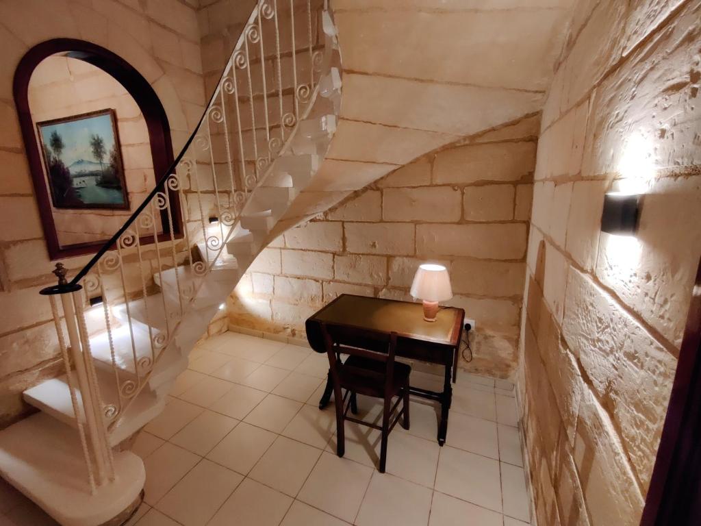 a small table in a room with a staircase at Peaceful Traditional Maltese Townhouse in Luqa