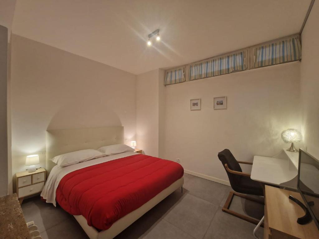 Schlafzimmer mit einem roten Bett und einem Schreibtisch in der Unterkunft La dimora del Conte in Trient